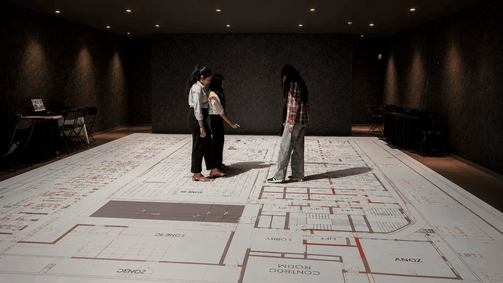 Architects walking a floor plan printed at full scale