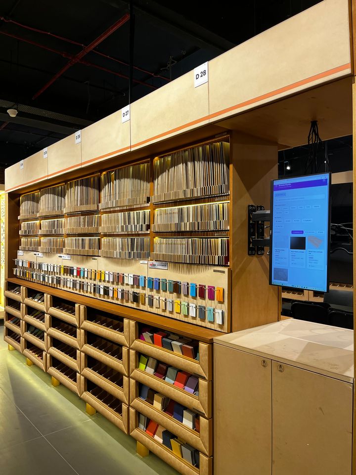 Knowledge Center physical display: curated material sample racks with a digital catalogue screen